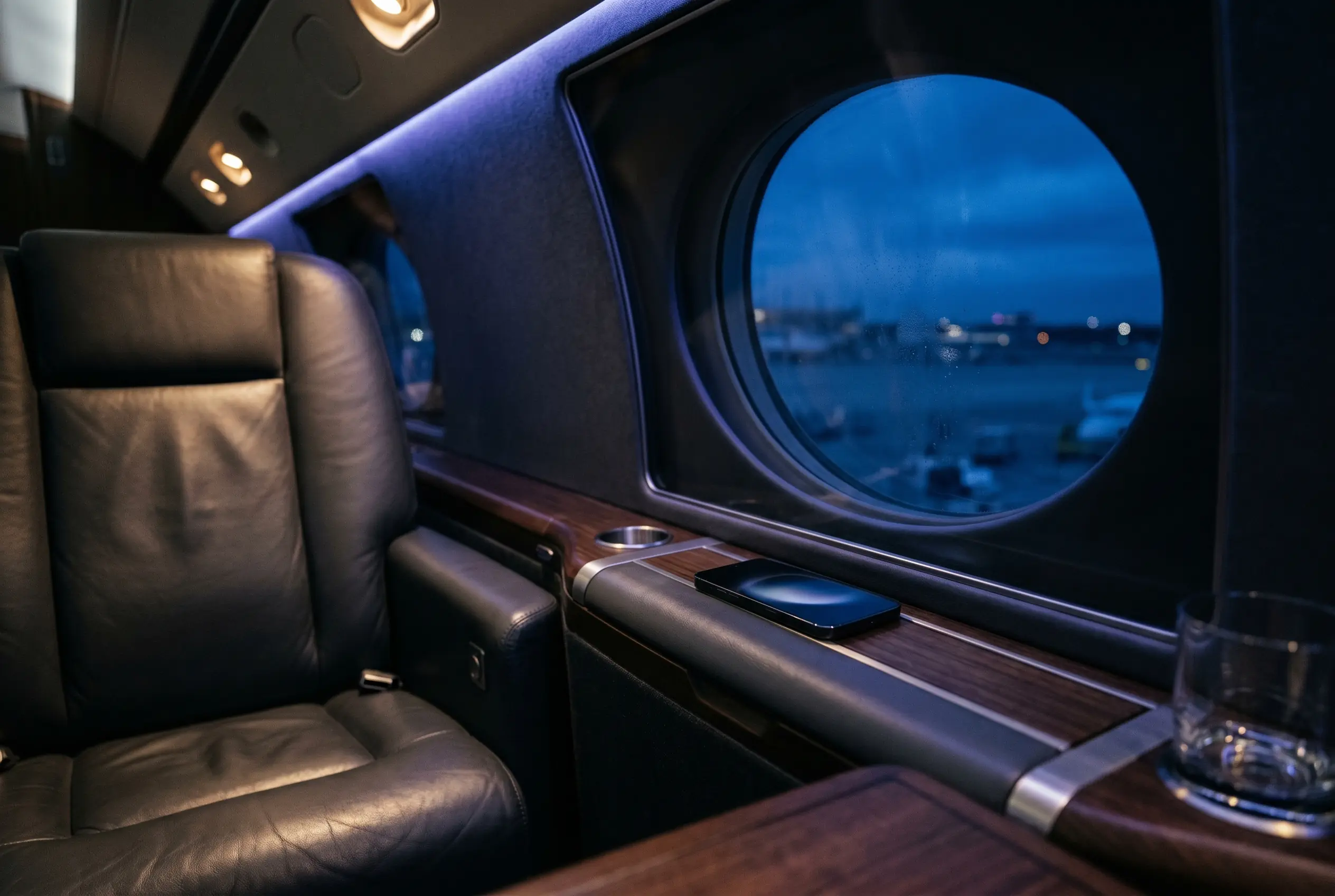 Traveller confirming a crypto payment on a phone in a private jet cabin before a New York to Miami flight