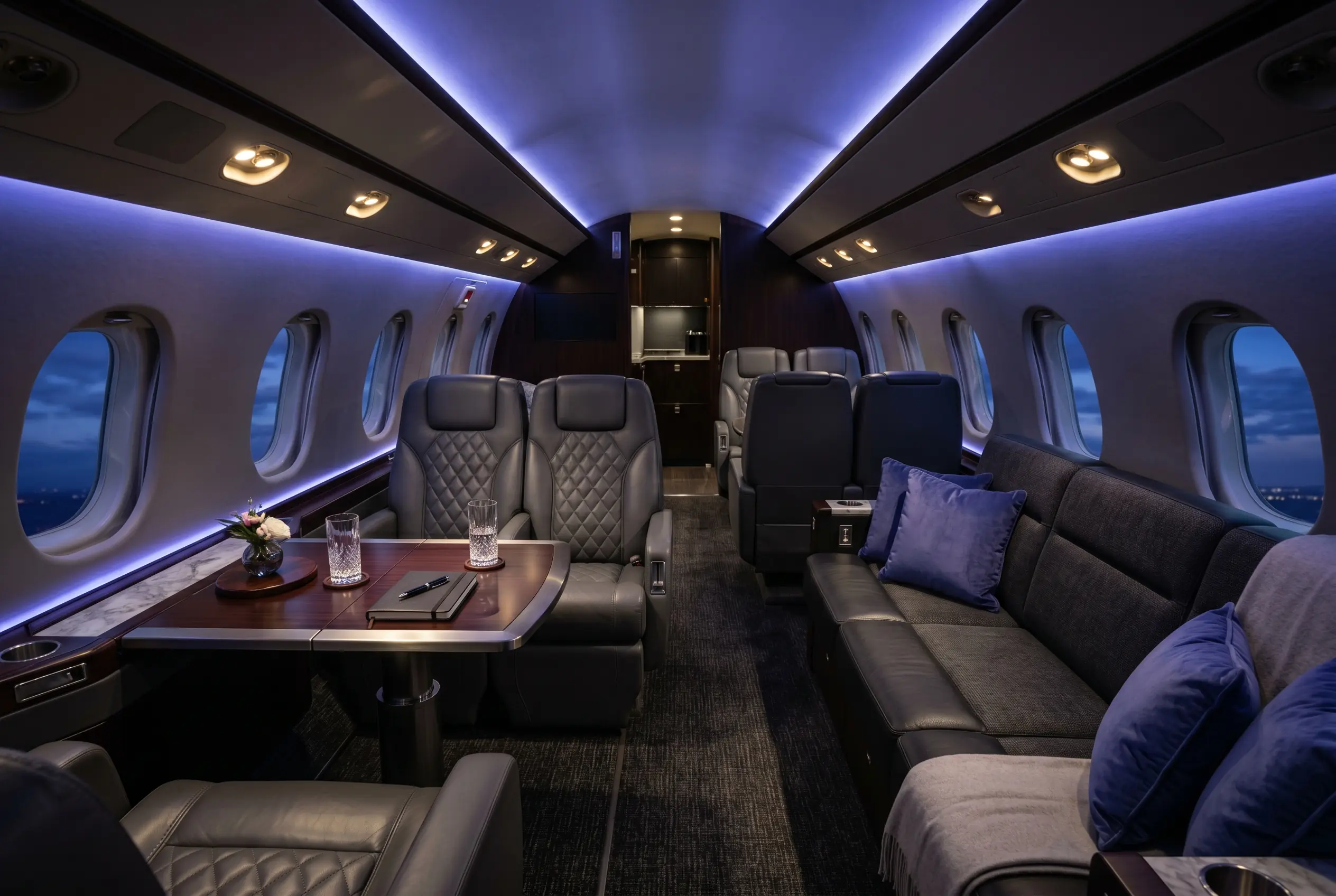 Bombardier Challenger 650 widebody cabin with facing club seats and a divan, configured for a New York to Miami charter