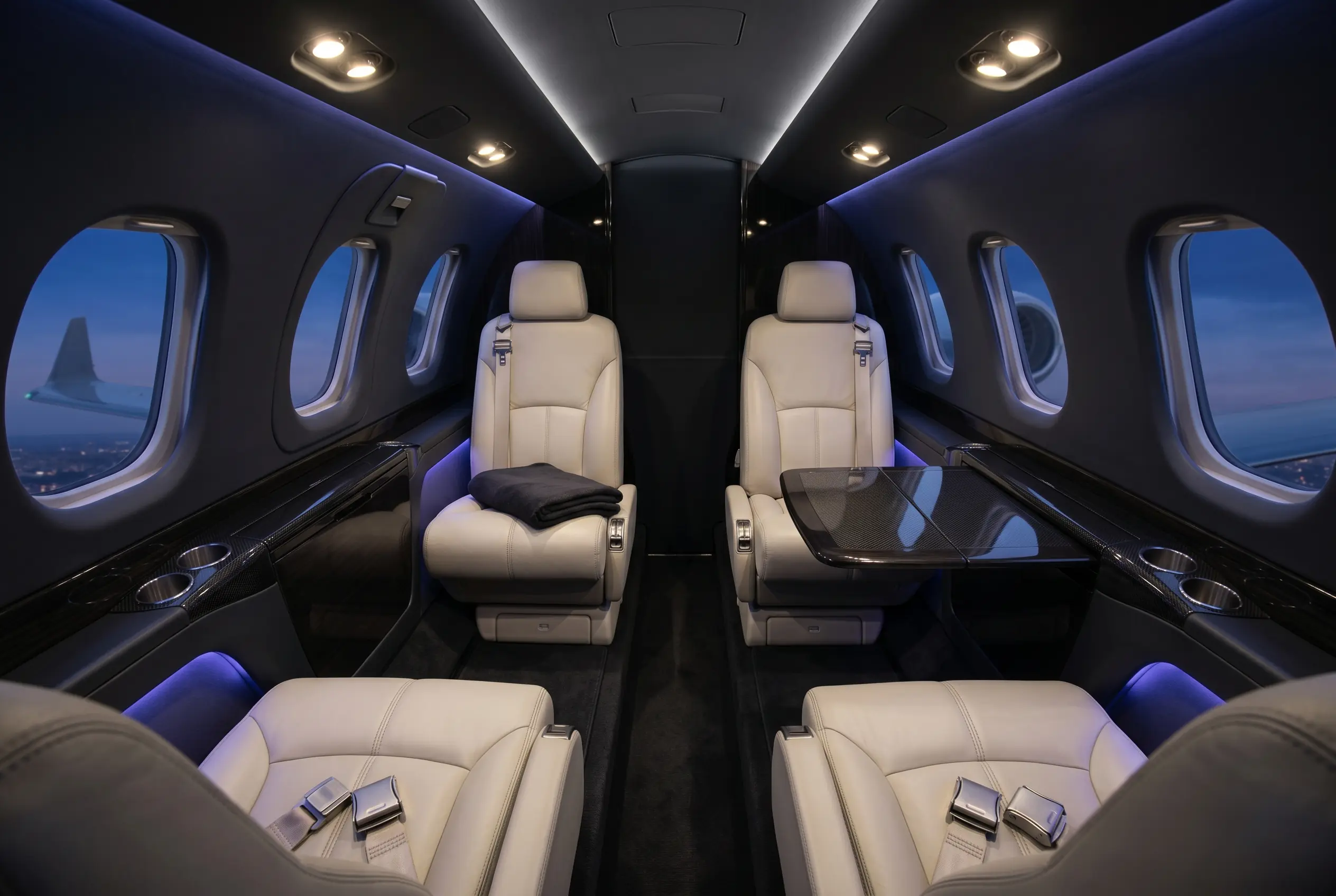 Cessna Citation M2 cabin with four club seats and light leather trim, configured for a New York to Miami charter
