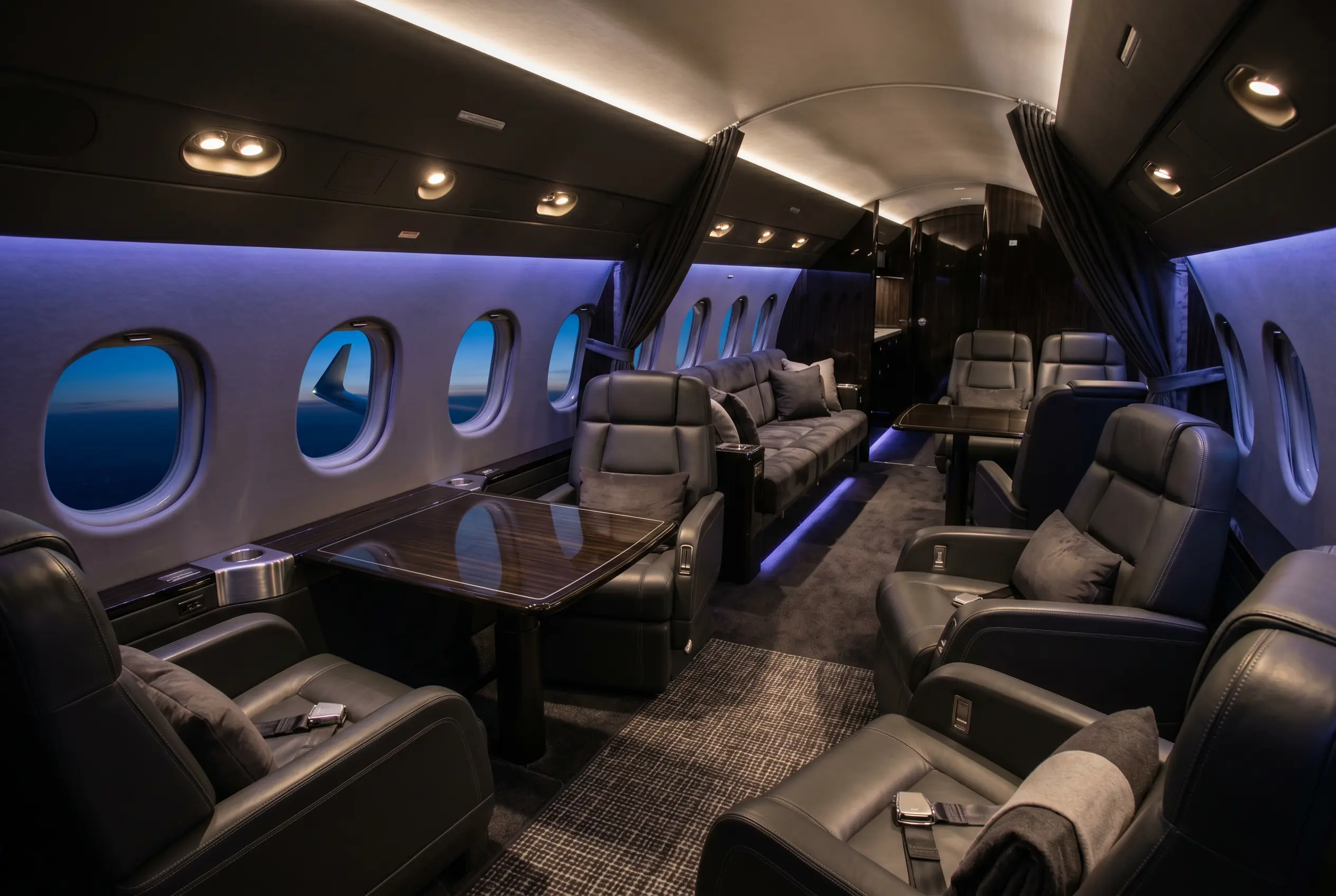 Dassault Falcon 900LX large cabin in three living zones with club and divan seating, configured for a New York to Miami charter