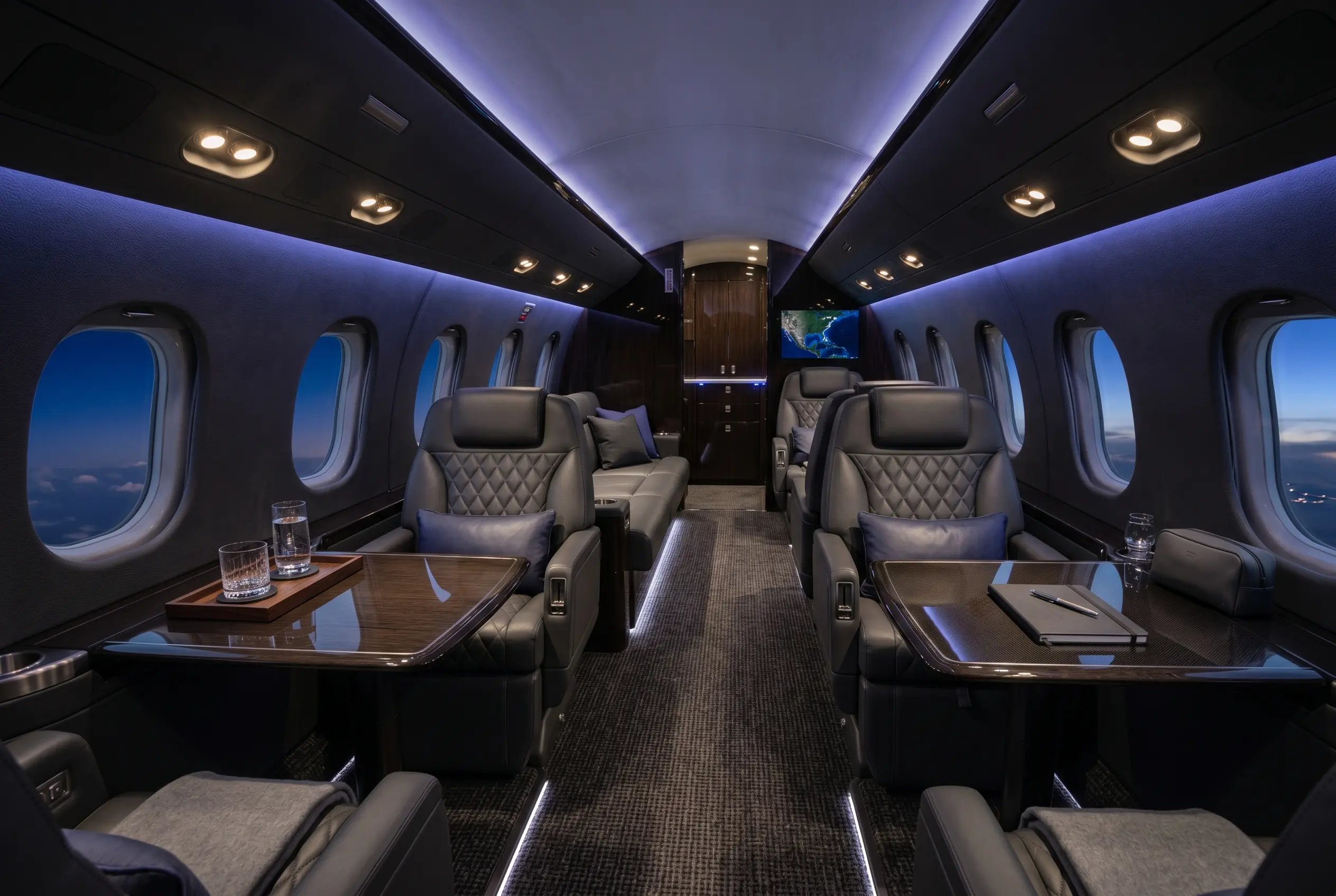 Wide super-midsize jet cabin with flat floor and club-plus-divan seating for a New York to Miami charter