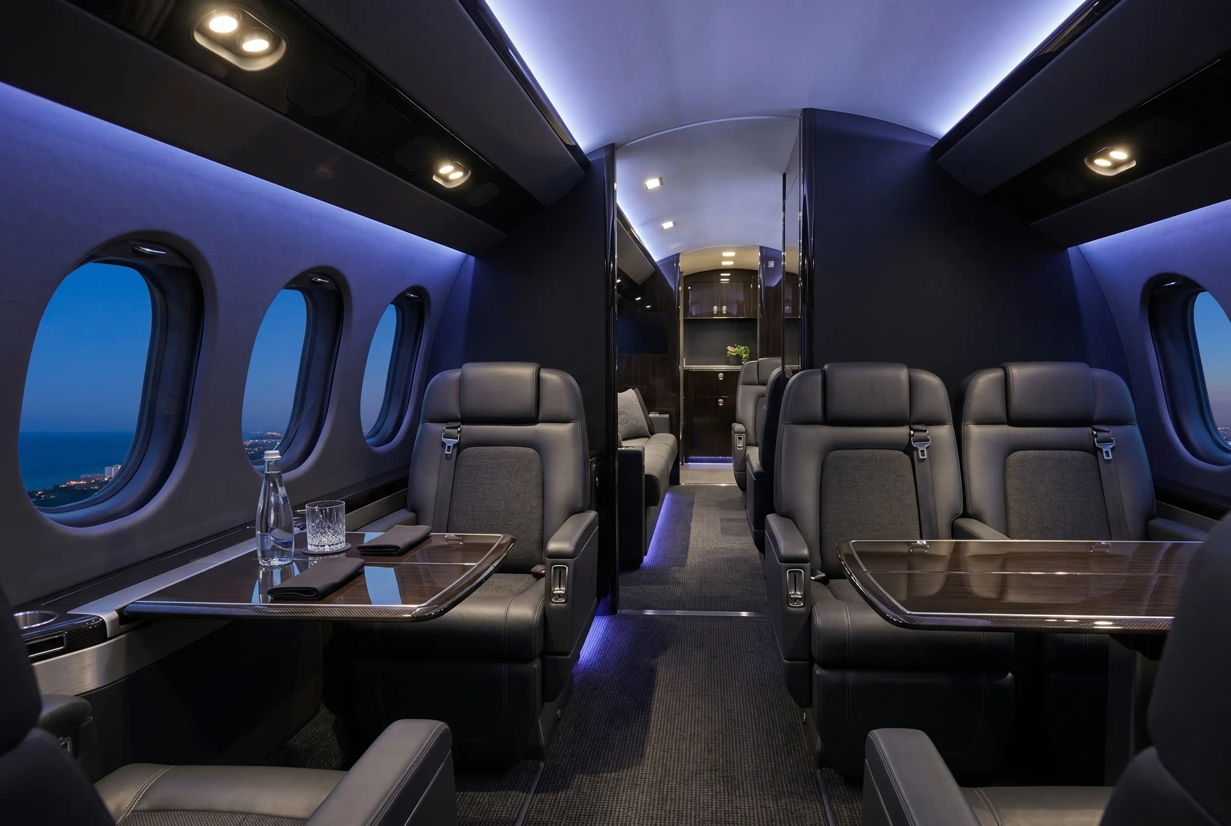 Ultra-long-range jet cabin with multiple living zones and wide club seating for a New York to Miami charter